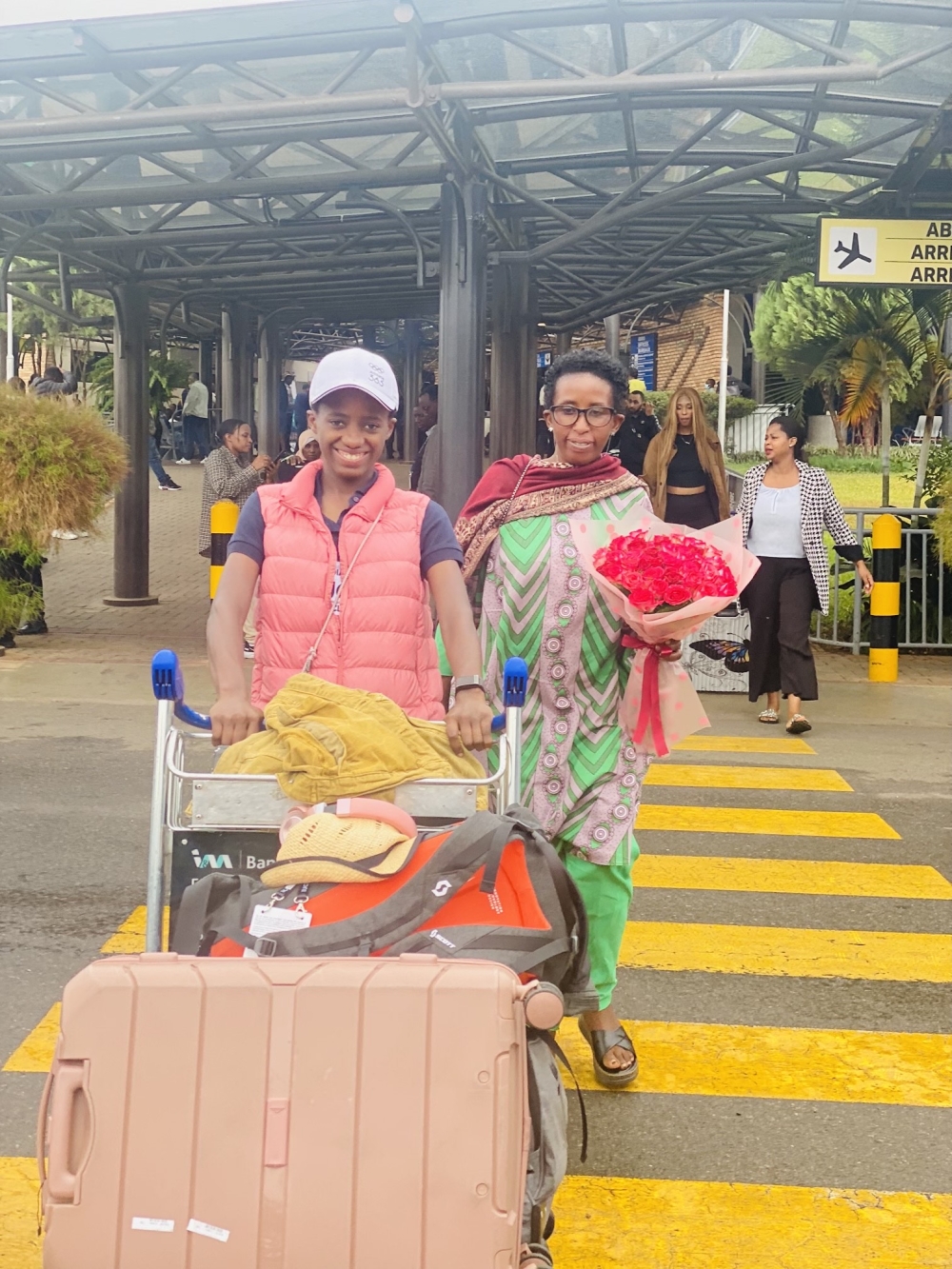 Mwamikazi and her parent on her arrival at Kigali International Airport from the UCI Road World Championship held in Zurich