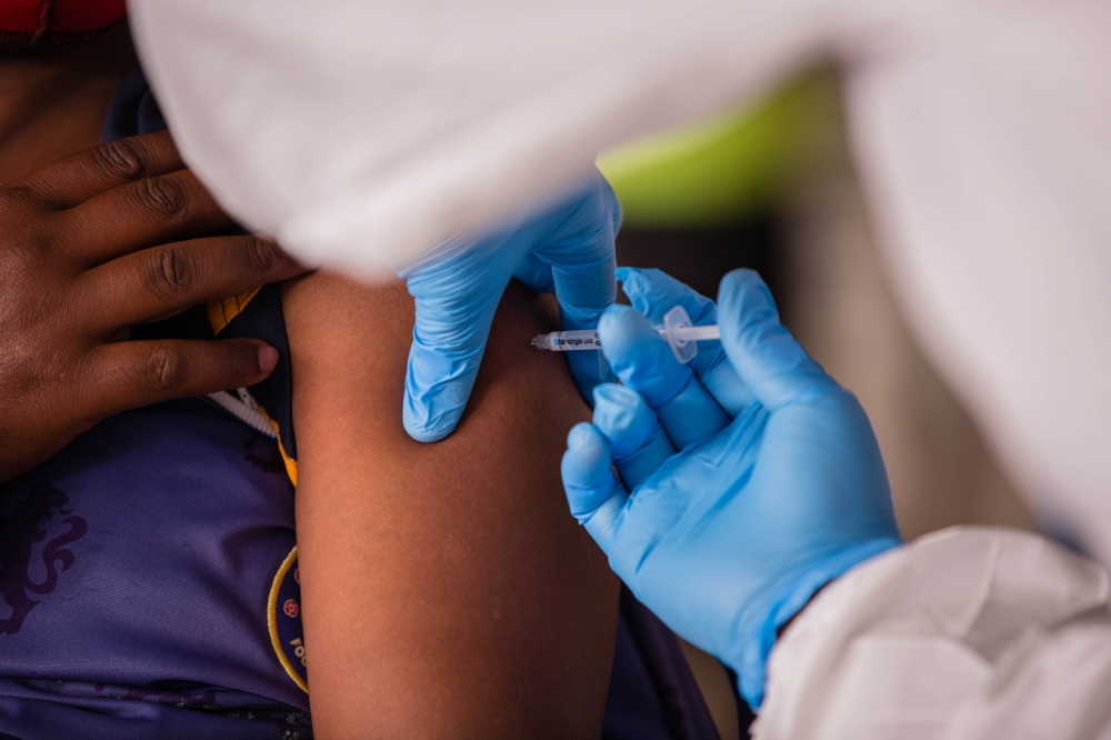 A health worker administers a vaccine. American pharmaceutical company Gilead Sciences will donate thousands of vials of its antiviral drug remdesivir to Rwanda. Photo by Craish Bahizi