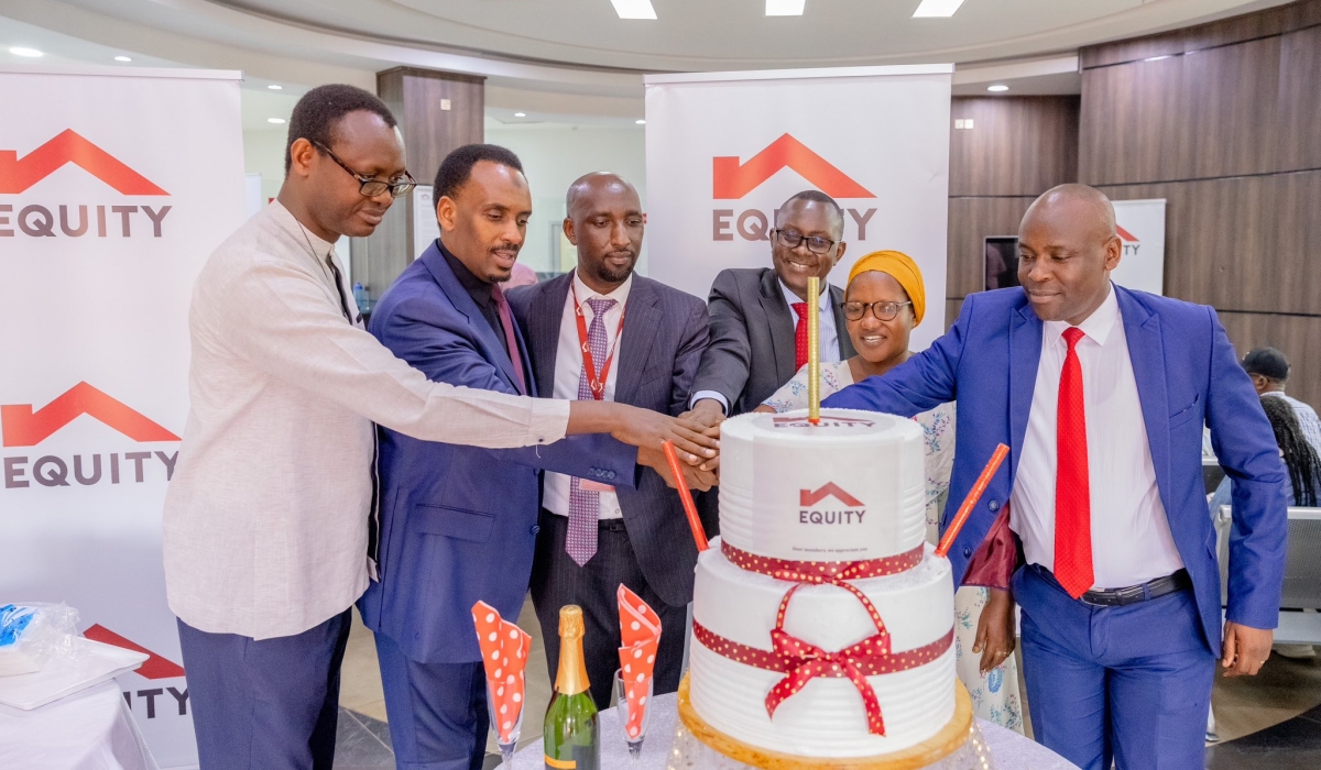 Equity Bank Rwanda officials and customers cut a cake as the bank kicked off its annual Customer Service Week celebration on Monday, October 7. Courtesy