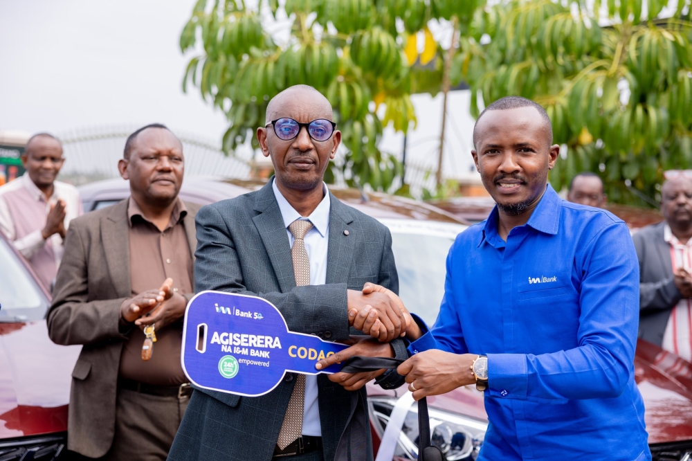 Chief Corporate Affairs Officer and Company Secretary at I&M Bank (Rwanda), Iddy Rugamba, (R) officially hands over the twelve cars to Assiel Nkusi, president of CODACE Cooperative on Sunday, October 6.