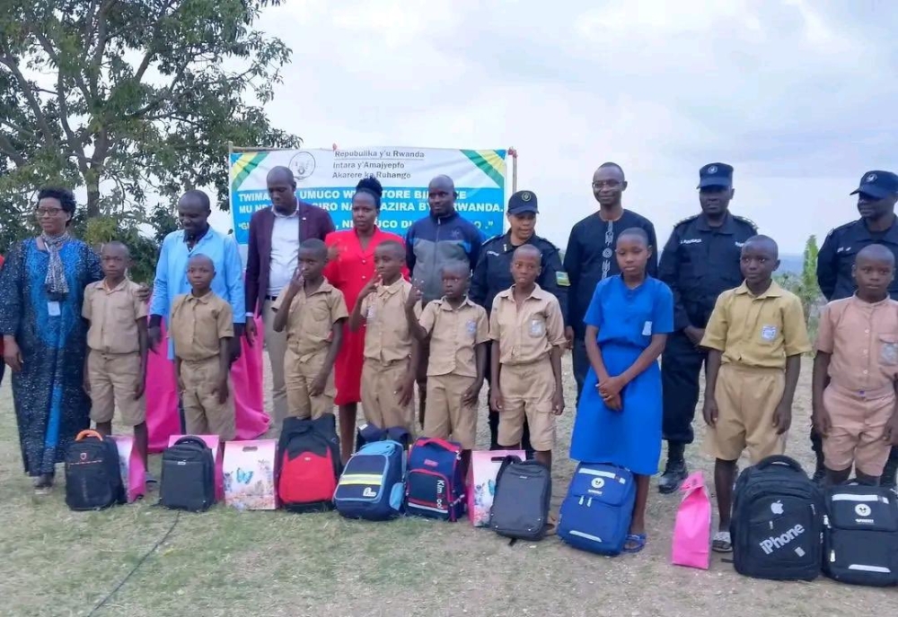 RNP officers and Ruhango District officials pose for a group photo with nine students from Cyove Primary School, during an awards event to honour them for bravely preventing the national flag from falling down.