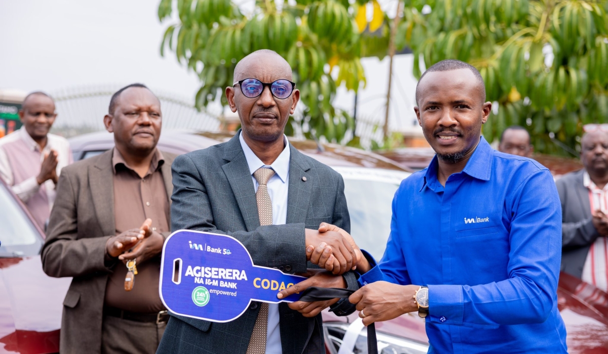 Chief Corporate Affairs Officer and Company Secretary at I&M Bank (Rwanda), Iddy Rugamba, (R) officially hands over the twelve cars to Assiel Nkusi, president of CODACE Cooperative on Sunday, October 6.