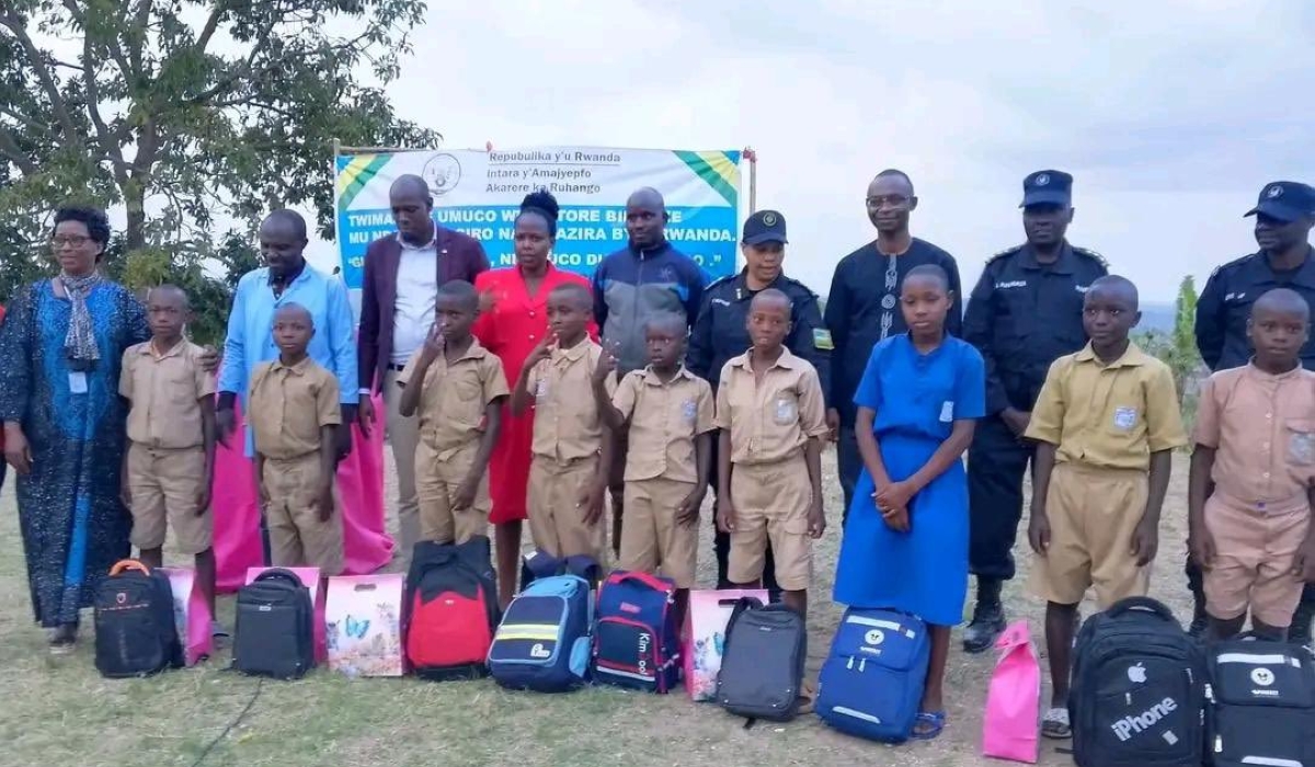 RNP officers and Ruhango District officials pose for a group photo with nine students from Cyove Primary School, during an awards event to honour them for bravely preventing the national flag from falling down.