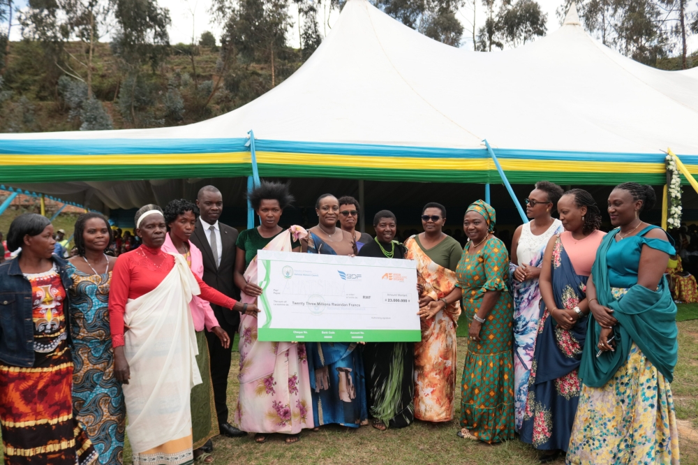 Minister of Gender and Family Promotion Consolee Uwimana hands over a cheque to members of a cooperative during the celebration in Nyamagabe District on Tuesday, October 15