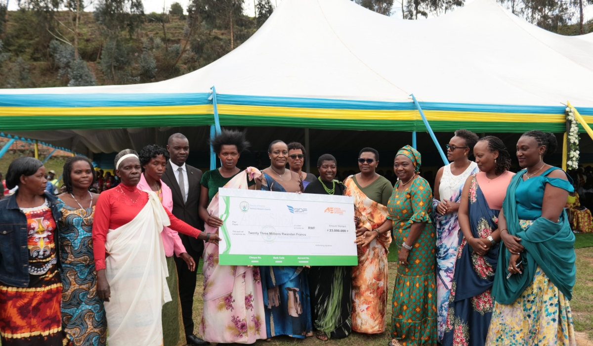 Minister of Gender and Family Promotion Consolee Uwimana hands over a cheque to members of a cooperative during the celebration in Nyamagabe District on Tuesday, October 15