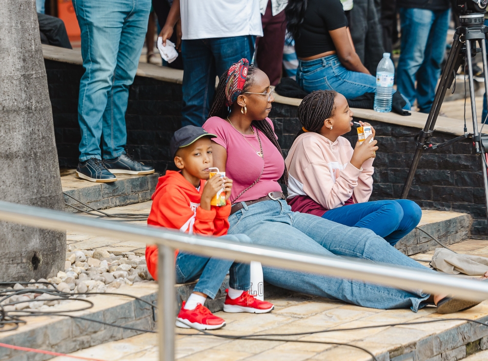 A mother and her children watch the rally at Kigali Heights