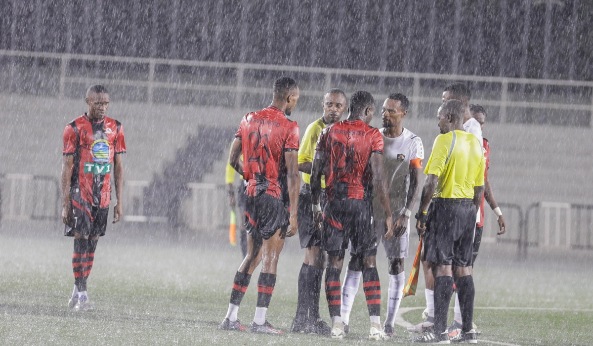 Referees talk to both skippers of the two teams before postponing the game due to heavy rain at Kigali Pele Stadium on Saturday, October 19. All Photos by Craish BAHIZI