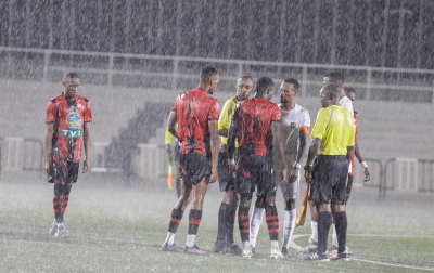 Referees talk to both skippers of the two teams before postponing the game due to heavy rain at Kigali Pele Stadium on Saturday, October 19. All Photos by Craish BAHIZI