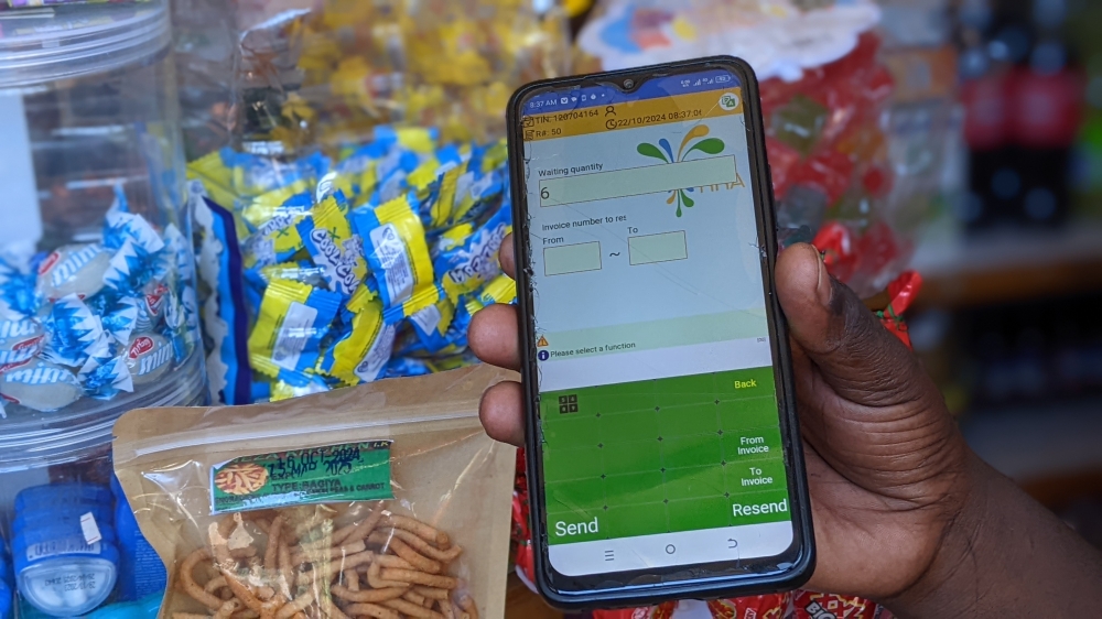 An EBM user shows off a phone app during an interview with The New Times in Rubavu town/Photos: Germain Nsanzimana