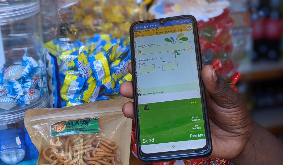 An EBM user shows off a phone app during an interview with The New Times in Rubavu town/Photos: Germain Nsanzimana