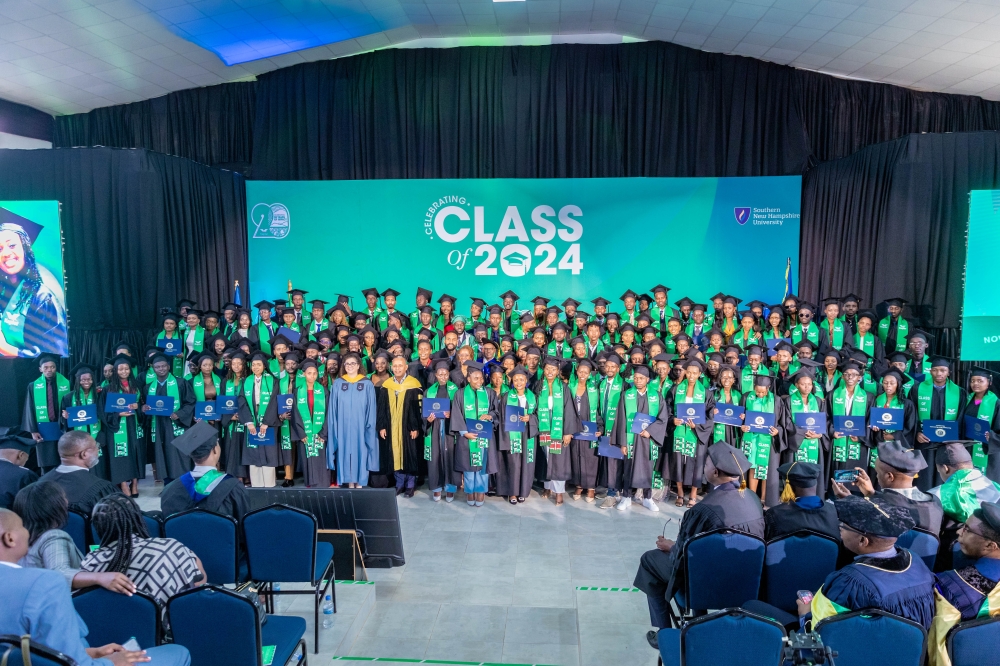 Graduates and officials pose for a group photo during the ceremony in Kigali on November 1,