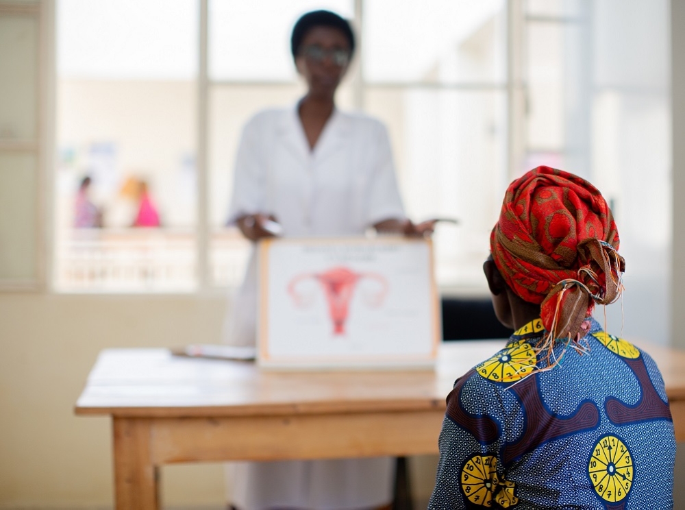 A nurse uses a poster to explain cervical cancer to a patient in Rwanda. It is a serious disease that poses a significant threat to women’s health worldwide. Photo Courtesy