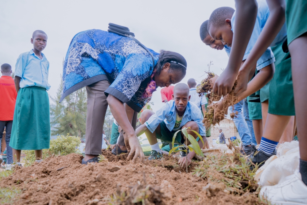 EP Kagina’s Director of Studies, Denyse Uwizeye, demonstrates tree planting to students while commending Mount Kigali University for the initiative.