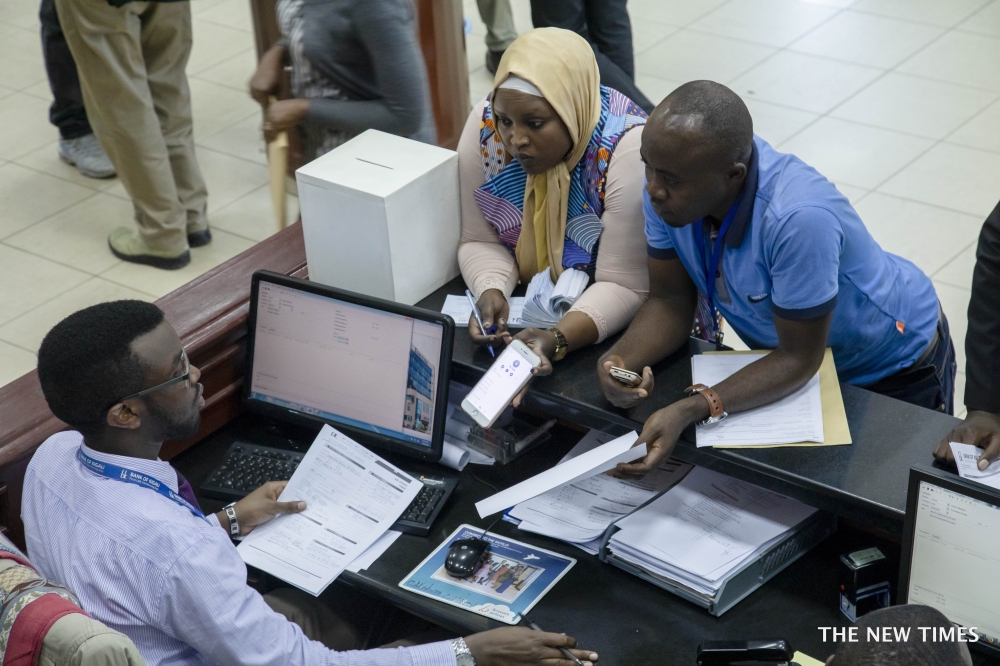 Bank of Kigali customers interact with the staff at the bank&#039;s main branch in Kigali. Photo by Sam Ngendahimana