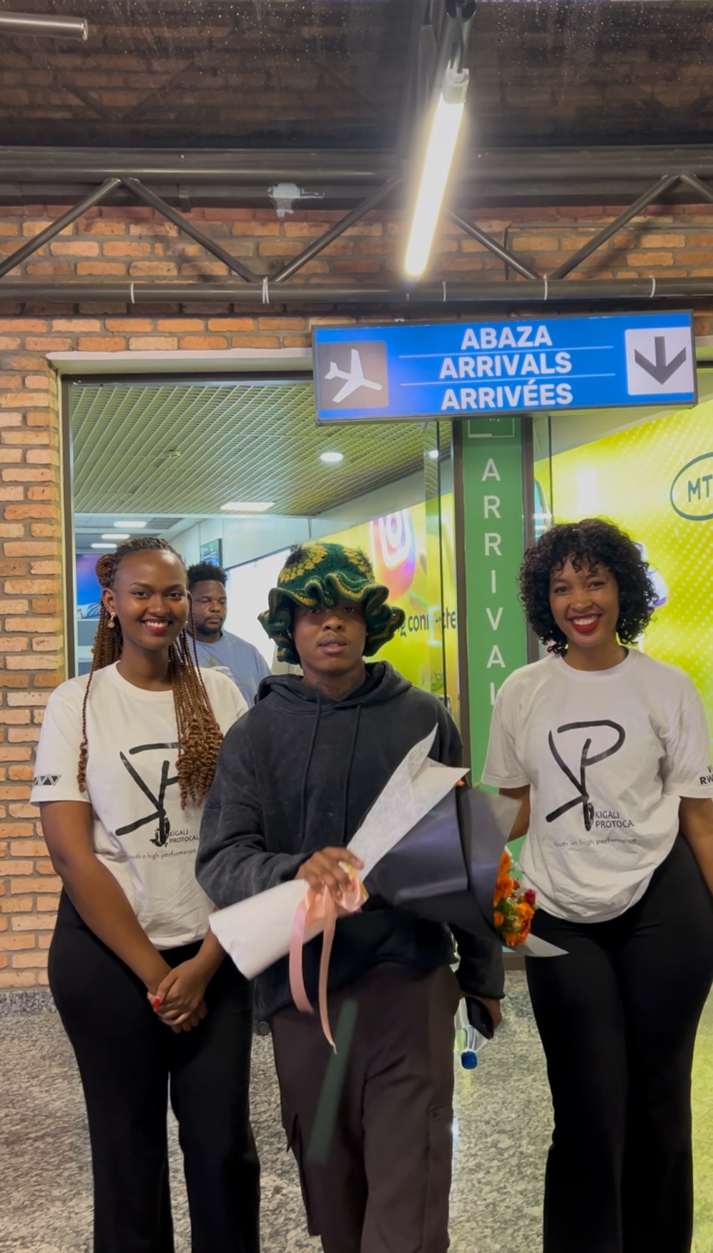 South African rapper Nasty C takes a photo with two young women from Kigali Protocol upon arrival at Kigali International Airport on Thursday night ahead of his performance at Davis D&#039;s Shineboy Fest-courtesy