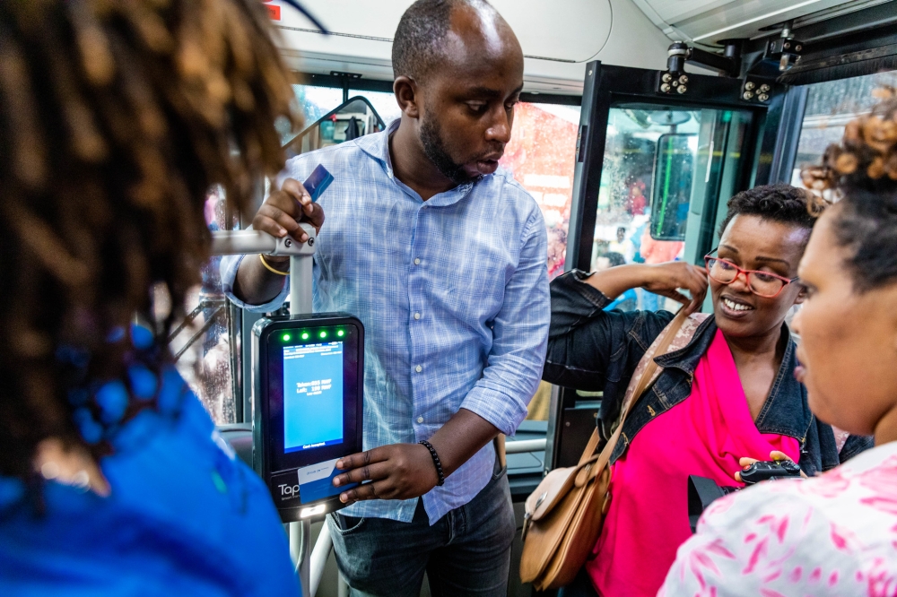 Commuters board a public bus during the launch of the distance-based fare system on Wednesday, December 4. All photos by Craish Bahizi