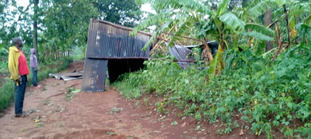 A resident pictured looking on,  on his neighboors roof which flew away due to heavy winds