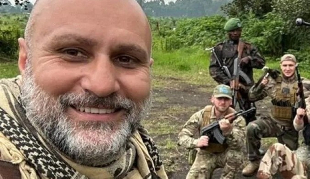 European mercenaries take a picture with a Congolese soldier as they brandish their guns. Courtesy.