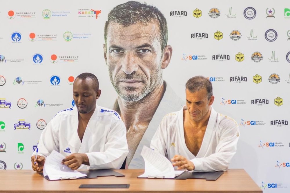 Renowned French karateka Christophe Pinna (R) and FERWAKA president Damien Niyomugabo sign a two-year agreement aimed at elevating the sport in Rwanda-Courtesy