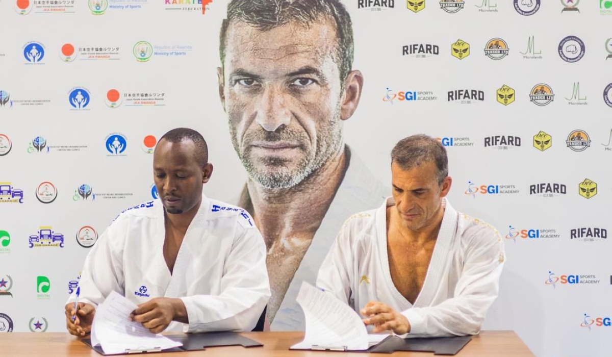 Renowned French karateka Christophe Pinna (R) and FERWAKA president Damien Niyomugabo sign a two-year agreement aimed at elevating the sport in Rwanda-Courtesy