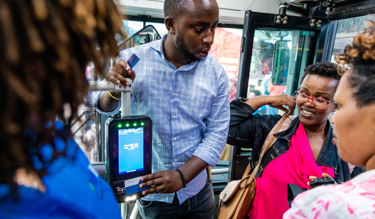 Commuters board a public bus during the launch of the distance-based fare system on Wednesday, December 4. All photos by Craish Bahizi