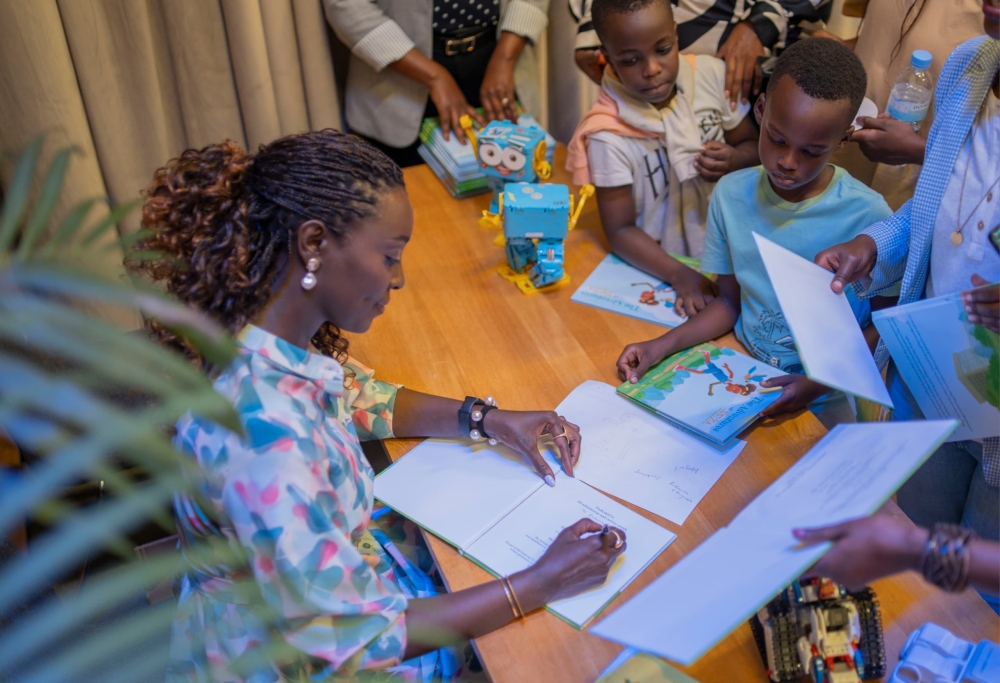 Author Stella Murungi  signs for the buyers during the launch of  her debut book “Adventures of FEZA”. Courtesy of Dennis Rukundo.