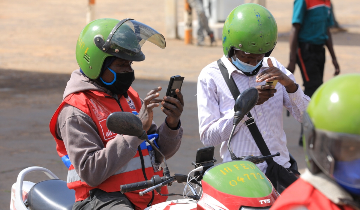 A moto taxi passenger pays the fare through mobile money in Kigali. File