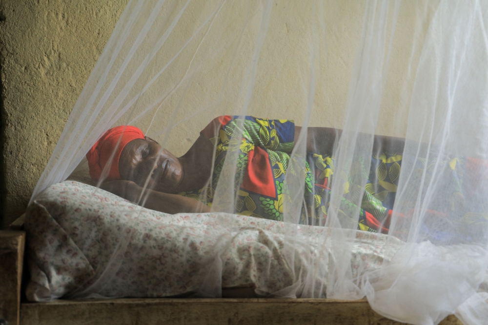 A woman sleeps under a mosquito net in Bugesera District during a malaria awareness campaign. File photo