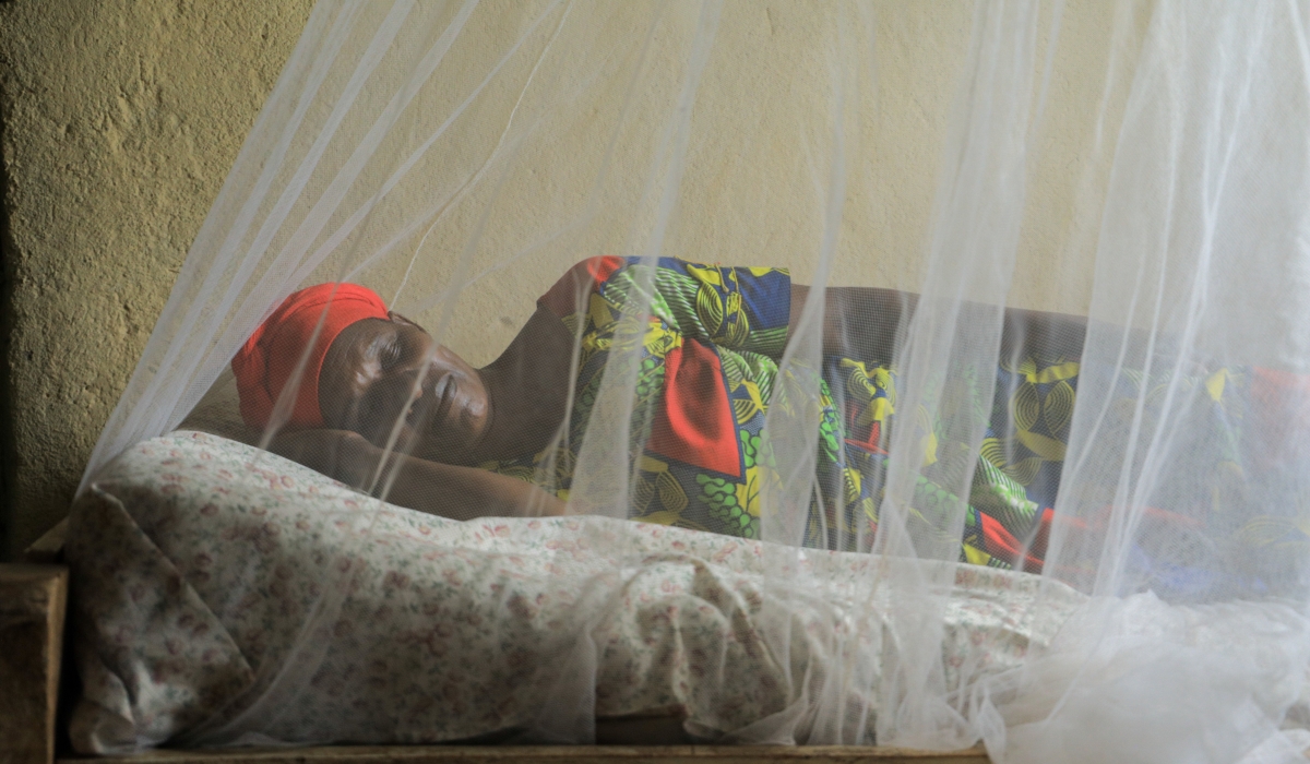 A woman sleeps under a mosquito net in Bugesera District during a malaria awareness campaign. File photo