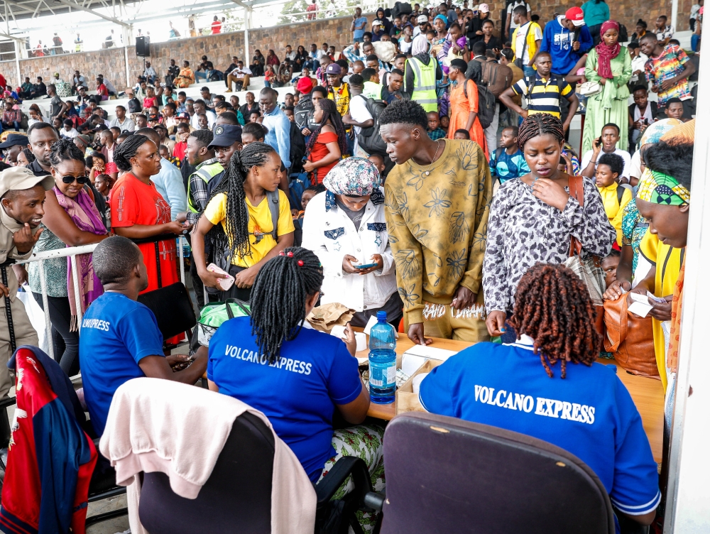 Ticket sellers serve travellers at Kigali Pele Stadium early Tuesday as thousands scrambled to catch buses en route to upcountry destinations on Christmas Eve. Photo by Craish Bahizi.