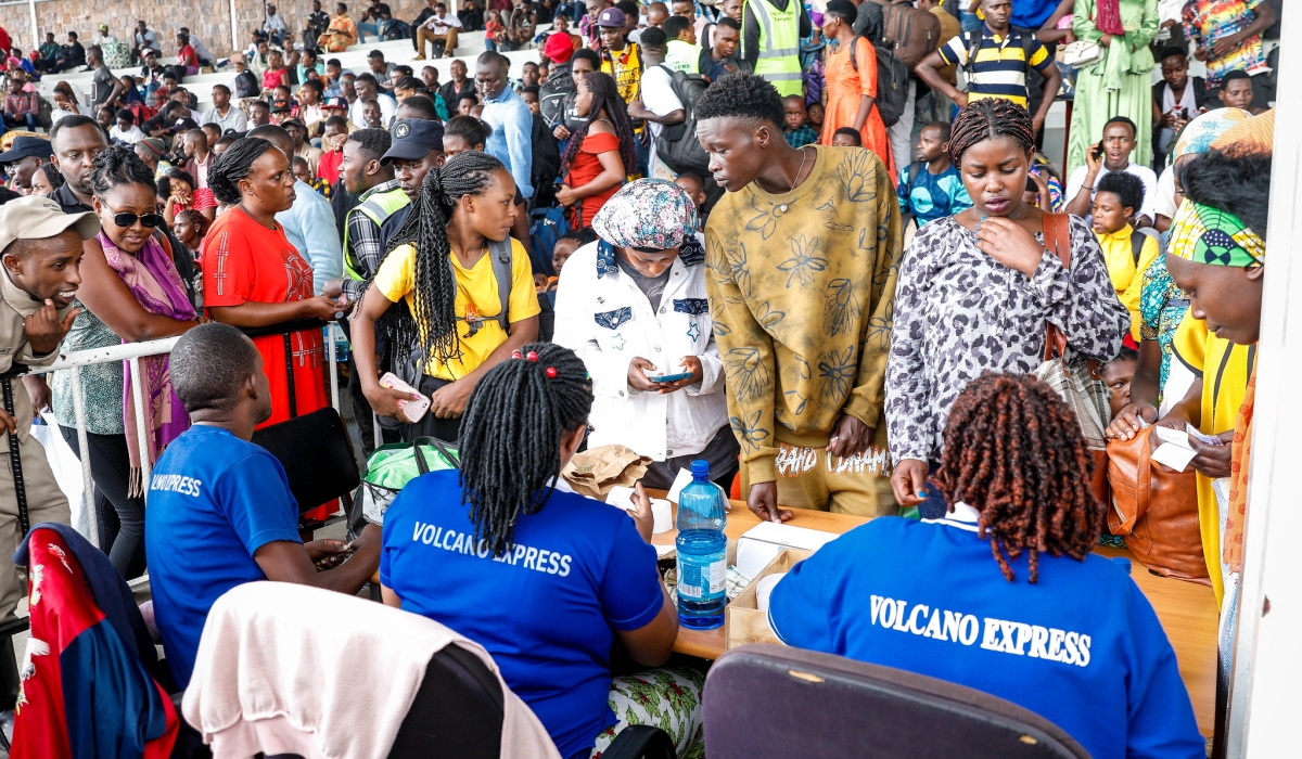 Ticket sellers serve travellers at Kigali Pele Stadium early Tuesday as thousands scrambled to catch buses en route to upcountry destinations on Christmas Eve. Photo by Craish Bahizi.