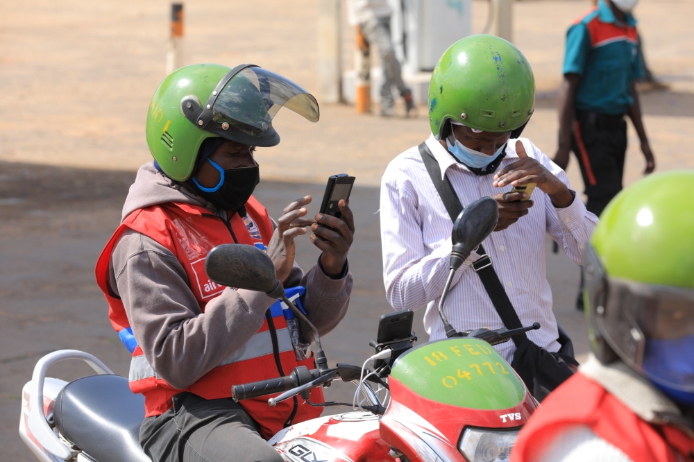 A moto taxi user pays the transport fee via Mobile money in Kigali.