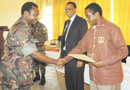 Dr Biruta (left) awards a certificate to Dr Uzziel Ndagijimana at the end of the two-week solidarity camp. Looking on is UNR Rector Prof. Silas Lwakabamba. (Photo/J. Mbanda)