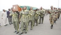 RDF officers carrying the casket containing Rutikangau2019s remains at Kigali International Airport yesterday.