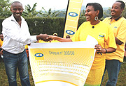 MTNu2019s Mary Asiimwe hands over a cheque worth Frw800,000 to Albert Nsabyimana of Kinyinya Orphanage. (Photo / M.Mazimpaka).