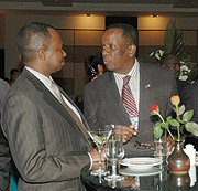 Karega (R) chats with business tycoon, Ezra Bunyenyezi, (L) during the EAIC