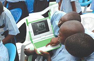 Kagugu Primary School boys try to take photographs with one of the Laptops given to them. (Photo/ J. Mbanda).