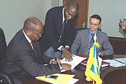 Minister of Finance and Economic planning James Musoni (L) signing a Grant Agreement with Claus Reiner (R) IFADu2019s representative in the East African Division, behind is George Katurebe, Director General CEPEX assisting them at the ministry building yested