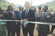 Tony Blair (C) cuts ribbon to open the new Nyirangarama juice factory. Left is its proprietor Gerard Sina. (Photo/ G.Barya)