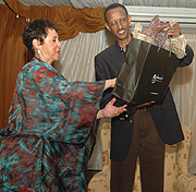 CARE Internationalu2019s Sheila Johnson gives present to President Paul Kagame on Monday. (PPU Photo)