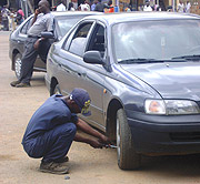 Evariste Nsegiyunva removing a vehicle tyre. (Photo / S. Tumusiime)