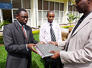 From Left, Emmanuel Werabe and Jean Marie Rutimirwa receiving a laptop during the event yesterday (Photo / M Odeth)