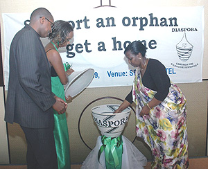 Foreign Affairs Minister Rosemary Museminali (R) makes her contribution as she launched the One Dollar Campaign at Serena Hotel Yesterday. (Photo/ J. Mbanda).