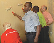 Staff of the Aegis Trust paint the Widowu2019s house in Kimironko yesterday. (Photo/ J. Mbanda)