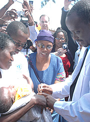 Health Minister, Dr. Richard Sezibera, administers a vaccine to one month  old Clementine Byukusenge belonging to Beatrice Mukamukama. (Photo/ G.Barya)