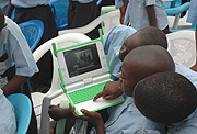 Kagugu Primary School boys take photographs with one of the Lap tops given to them in the One Laptop per Child campaign. (File Photo).