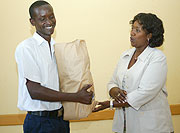 Health Ministry Permanent Secretary Agnes Binagwaho presenting gifts to overall winner Michael Mugengana on Monday (Photo / G. Barya)