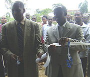 RDRC chairman John Sayinzoga and Karongi District Mayor Bernard Kayumba cutting the ribbon to launch one of the houses. (Photo/ D. Ngabonziza)