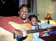 Patrick Mureithi playing guitar to his beautiful daughter