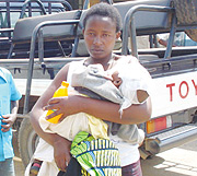 Angelique Munganyinka carries an baby belonging to an unidentifed injured mother. (Photo/ D.Sabiiti)